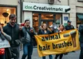 Radikale Demonstration im Rahmen des veganer Aktivismus vor einem Bastelladen mit Megaphonen und Transparenten.