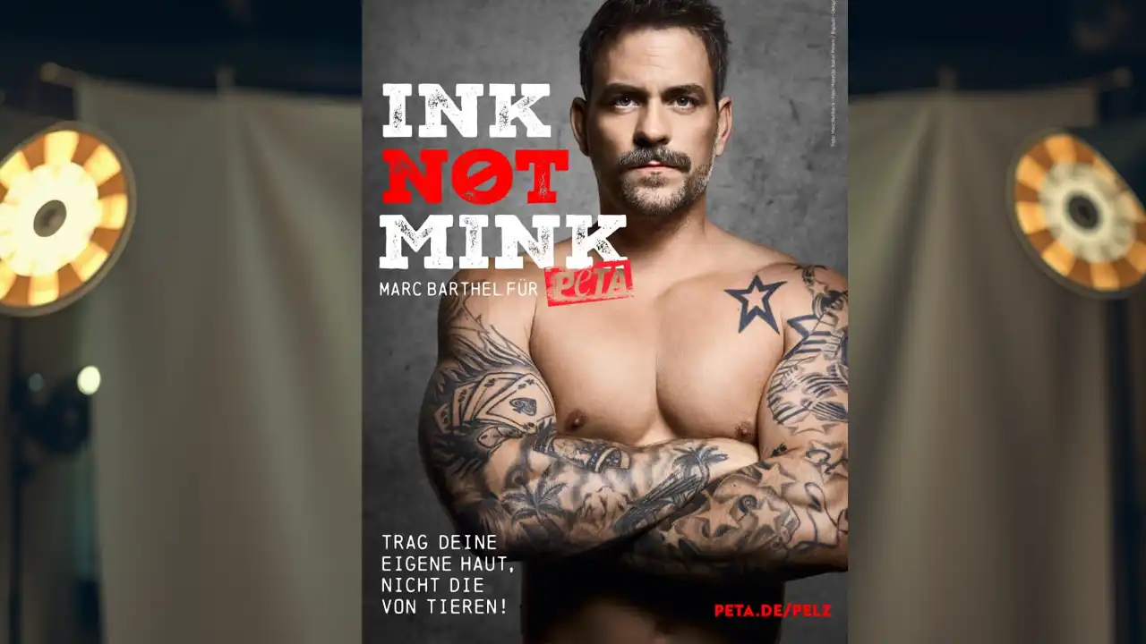 Der tätowierter Marc Barthel steht oberkörperfrei im Studio und blickt ernst in die Kamera, das Licht betont seine Haut und spiegelt die Spannung der Pelzindustrie Kritik wider