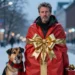 Detlef Steves PETA als menschliches Weihnachtsgeschenk in winterlicher Umgebung mit Hund neben sich.