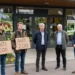 Fotorealistische Szene vor einem deutschen Zooeingang, in der Anti-Zoo-Aktivisten auf sachlich argumentierende Zoo-Experten treffen und sichtbar in Erklärungsnot geraten.