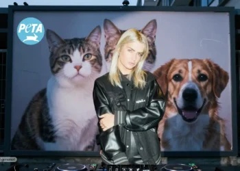 LOVRA steht vor einer Hochglanzkampagne mit Tiermotiven, während im Hintergrund ein dunkles Tierheim mit leeren Käfigen sichtbar wird