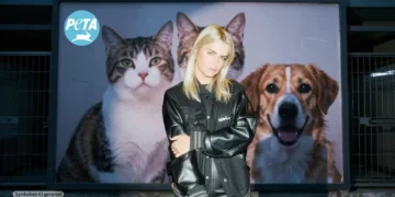 LOVRA steht vor einer Hochglanzkampagne mit Tiermotiven, während im Hintergrund ein dunkles Tierheim mit leeren Käfigen sichtbar wird