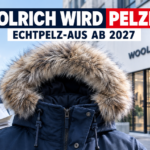 Eine moderne Winterjacke mit Kunstfellbesatz symbolisiert, dass Woolrich wird pelzfrei.